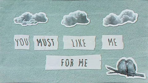 Lyric video frame with paper-cut clouds and words on textured paper